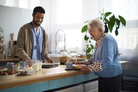 A older woman in a nursing home is delighted by all the choices available to her in the cafeteria