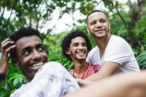 Three men around each other, while one man is embracing another.